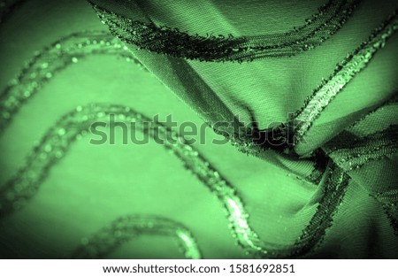 texture  background picture the fabric is transparent emerald green with brightly innate stripes, the material allowing the light to pass through it so that the objects behind are clearly visible.