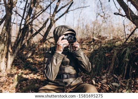 Senior man taking photo in nature. Mature man taking pictures of the forest in fall.