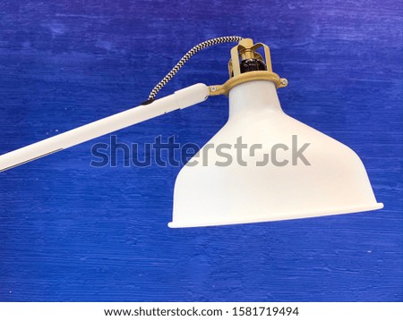 White lamp on a blue wall background.
