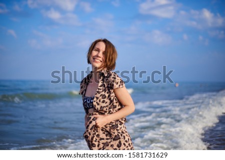 woman by the sea in a leopard print dress