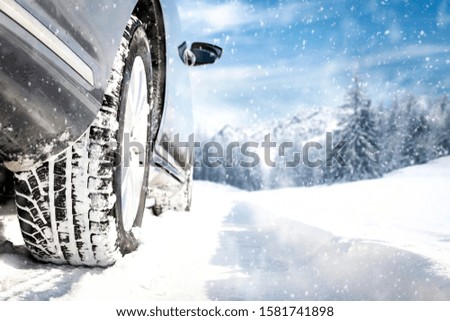 Gray winter car on road with snow.Free space for your decoration.Snowflakes and forest of frost.Cold december day.