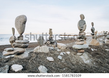 Figures of stones on the beach near the sea. Sea background and stone figures.