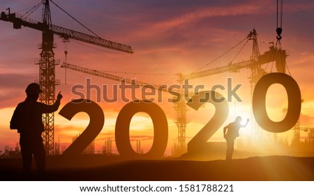 Cranes building construction 2020 year sign,Silhouette staff works as a team to prepare to welcome the new year 2020 Royalty-Free Stock Photo #1581788221