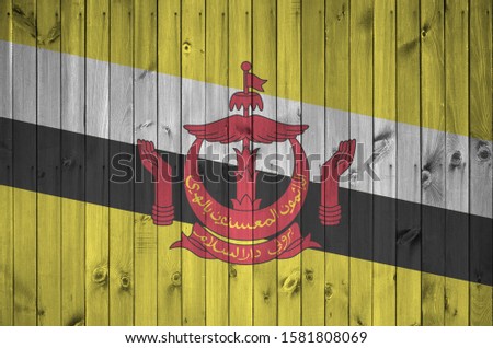 Brunei Darussalam flag depicted in bright paint colors on old wooden wall. Textured banner on rough background