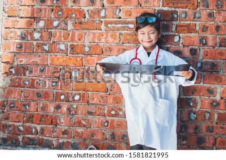 Happy little girl in doctor costume holding sthetoscope