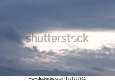 Picture of the morning sky with white, cotton like clouds forming a hole.
