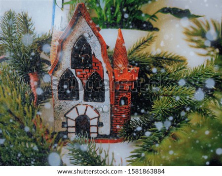 Christmas candlestick, stylized as an old half-timbered German house among spruce branches. Snow. Bokeh. Christmas theme. New Year card