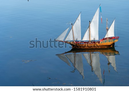 Wooden toy galleon ship sailing in a lake