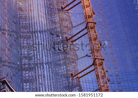 A modern glass and steel tower under construction 