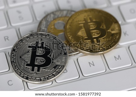 Cryptocurrency metal coins lie on white laptop keyboard.