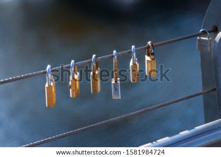 Padlock hanging on steel wire as a symbol of eternal love and togetherness