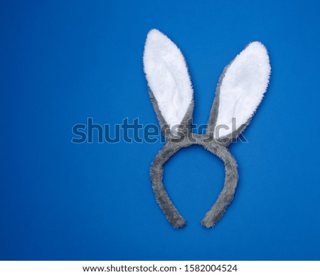 Fur headdress of a hare with ears on a dark blue background, festive attribute of fancy dress, trendy color 