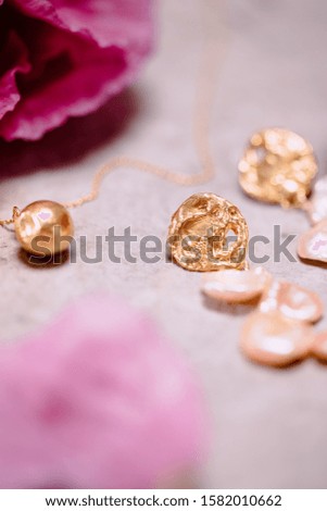 A vertical shot of trendy luxurious golden jewelry on white background
