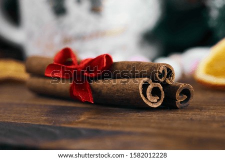 Cinnamon tied with a red bow on a wooden background. new year picture