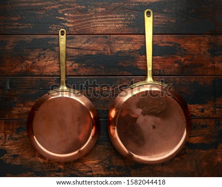 french Vintage Copper saute pans, kitchen utensil on wooden background Royalty-Free Stock Photo #1582044418