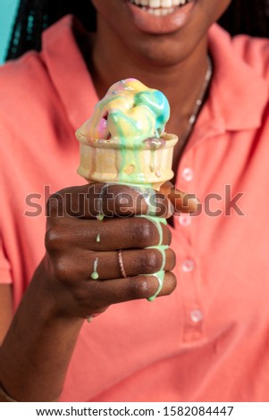 Close up of a dripping ice cream cone being eaten by an African American Woman. Fun messy desert concept.