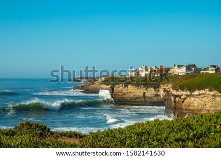 Crashing waves on West Cliff Dive in Santa Cruz, with houses in the background