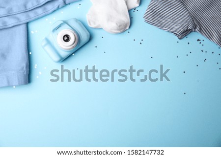 Flat lay composition with toy camera on light blue background, space for text. Future photographer