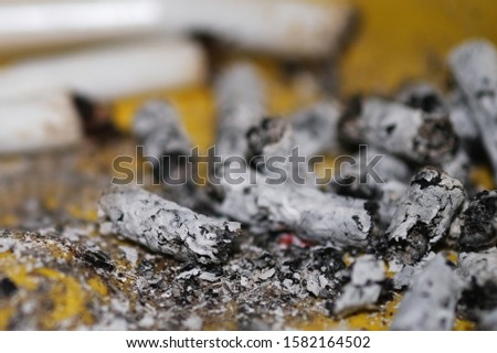Cigarette ashes and cigarette butts close-up. Macro. Selective focus.