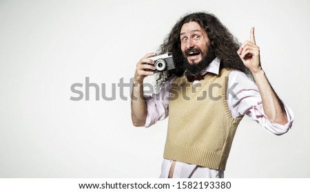 Funny bearded man with a retro photo camera