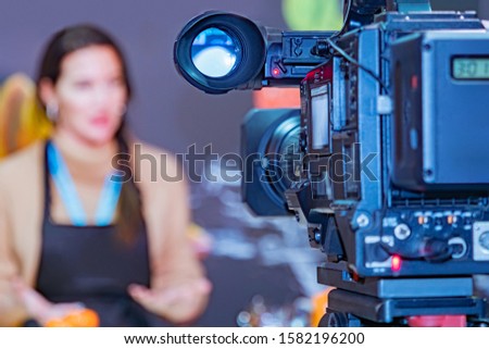 News release filming. Reporting on a professional camera. Work video operators. Recording an interview. Concept - journalism. Professional camera is aimed at the girl. 