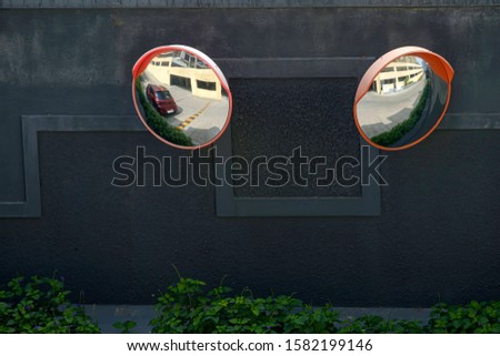 Two convex mirrors for traffic safety on a wall in a housing society at Pune India.