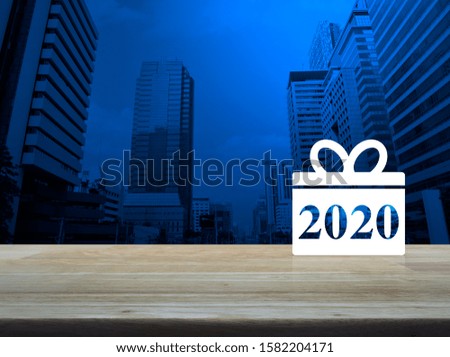 Gift box happy new year 2020 flat icon on wooden table over modern office city tower building and skyscraper, Business shop online concept