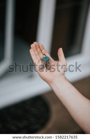 A closeup of a person hand holding keys with a blurred background
