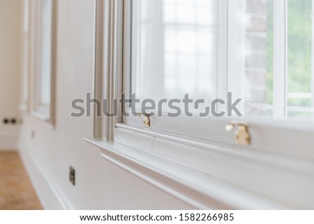 A closeup shot of a gold sash lock on a white window Royalty-Free Stock Photo #1582266985