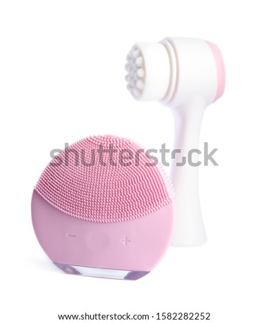 Modern electric face cleansing brushes isolated on white. Cosmetics tools