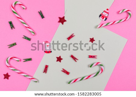 Christmas composition. Candy, wooden toys and stars on pink and green background. Christmas, winter, new year concept. Flat lay, top view