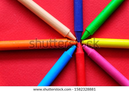 Colorful crayon on red background.