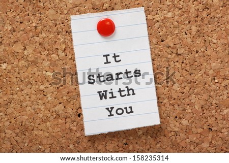 The words It Starts With You typed on a scrap of lined paper and pinned to a cork notice board. A concept for customer service or self improvement, adapting to change or making plans. Royalty-Free Stock Photo #158235314