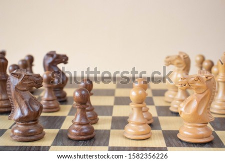 Detail of a chess game over a chessboard on a beige background