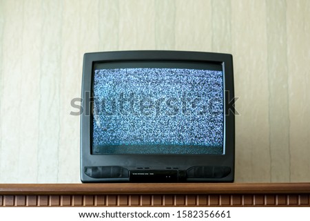 television with no screen signal on wood shelf in apartment