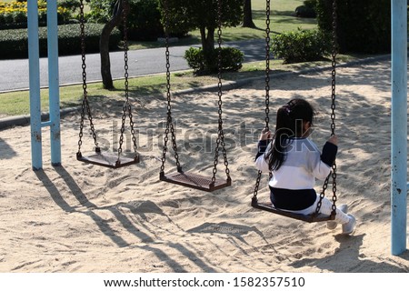 

Girl playing swing in Bangkok Park, Thailand. Place the subjector in the corner, there is space left for inserting text for different functions.
