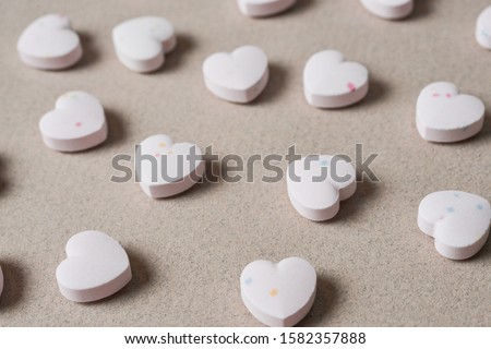 Heart shaped candies on paper texture background