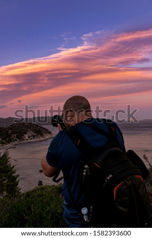 Man taking a photos with dslr camera outdoors. Photographer taking travel nature photography