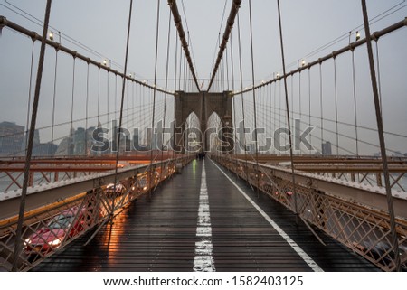 Brooklyn Bridge, New York with the skyline in the background on a cloudy and misty day