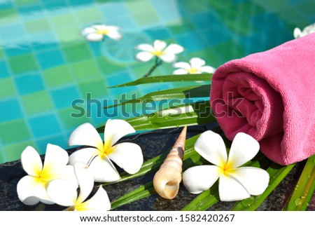Beauty spa water. Towels, palm leaf on the water. The concept of relaxation and meditation. Body care is health. Relax in the swimming pool. Tropical vacation.