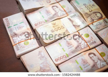 Thai banknotes on wooden background. Kind of thousand Thai baht. Money concept.