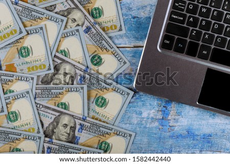 Paper money 100 dollar bills on laptop modern computer keyboard financial concept