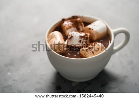 Cocoa drink with marshmallow in white cup on terrazzo surface