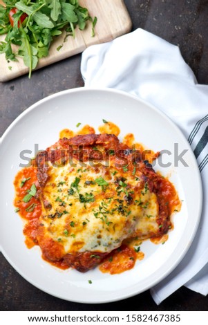  Chicken Parmesan or parmigiana. Italian comfort dish. Chicken breast covered in breadcrumbs fried, topped with marinara sauce, melted mozzarella, parmigiana and provolone cheeses and Italian parsley. Royalty-Free Stock Photo #1582467385