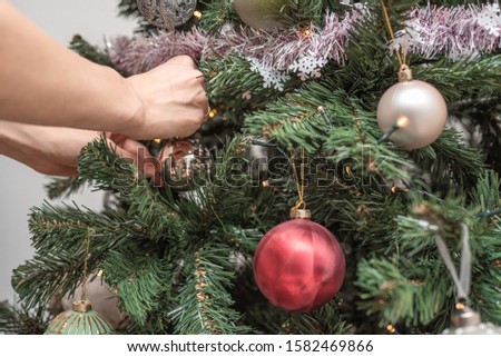 Woman hands decorates christmas tree