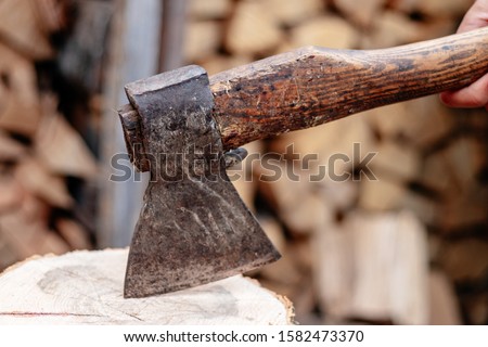 An ax stuck in a log. Ax blade close.