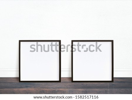 Two black square frame image mockup. White background and black desk.