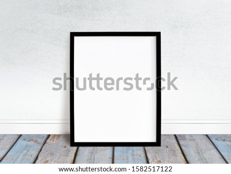 Empty blackframe image mockup. White wall and bright desk floor.