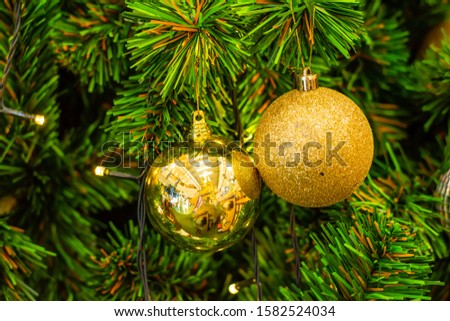 Decorated Christmas tree closeup. Red and golden balls with lights bokeh background. Winter holiday light decoration