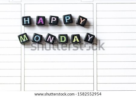 Happy Monday of blocks on white page open notebook on desktop